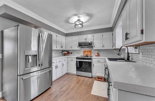 kitchen featuring stainless steel appliances, tasteful backsplash, crown molding, white cabinets, and sink