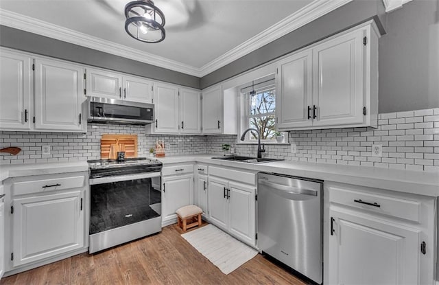 kitchen with appliances with stainless steel finishes, white cabinets, and sink