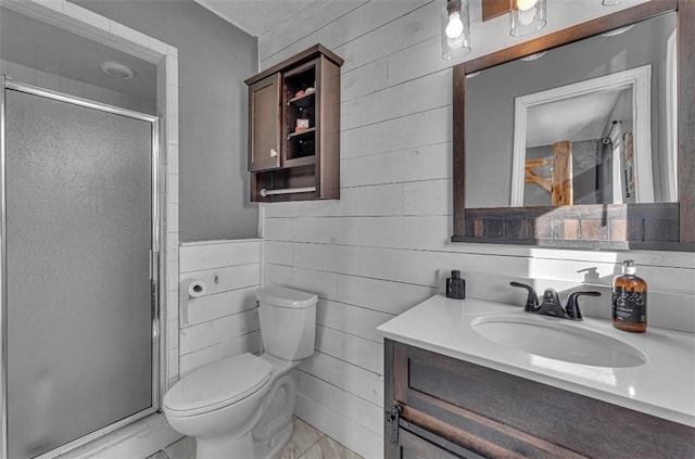 bathroom with toilet, a shower with shower door, wood walls, and vanity