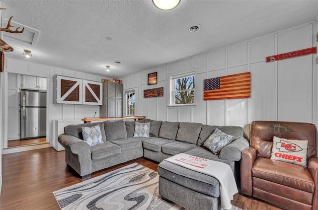 living room featuring a textured ceiling and dark hardwood / wood-style floors