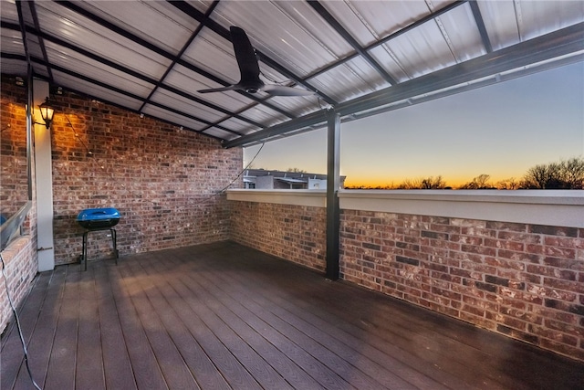 deck at dusk with ceiling fan and area for grilling