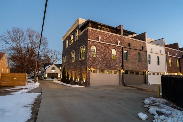 view of snowy exterior featuring a garage