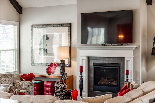 living area with a fireplace and lofted ceiling with beams