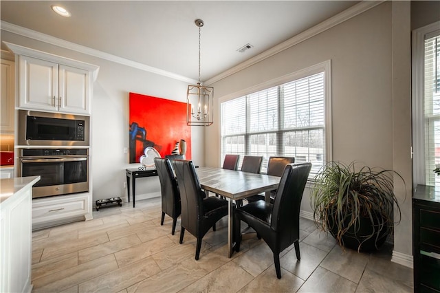 dining room with a notable chandelier and crown molding