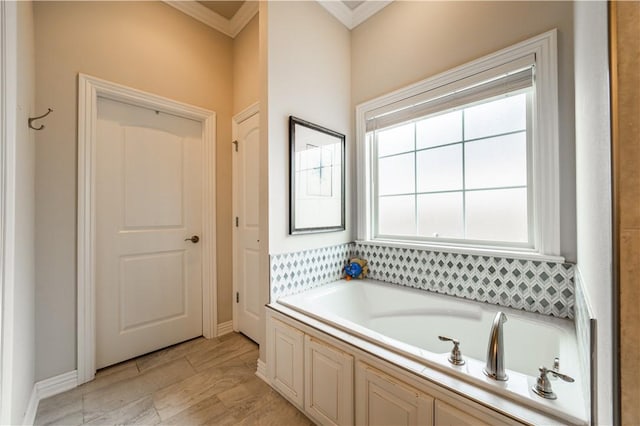 bathroom with a tub and ornamental molding