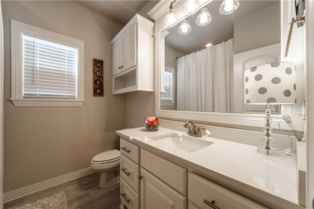 bathroom with toilet, vanity, and wood-type flooring