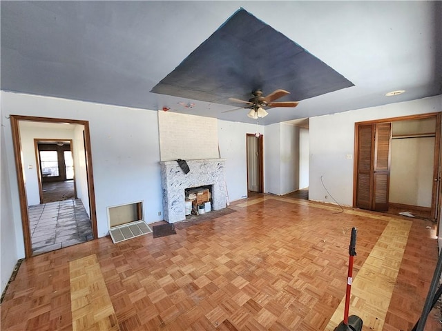 unfurnished living room with ceiling fan and light parquet flooring