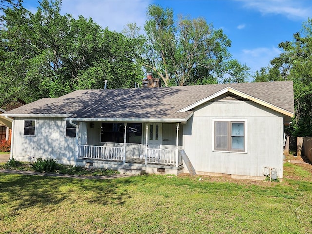 ranch-style home featuring a chimney, roof with shingles, a porch, and a front yard