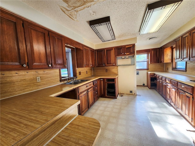 kitchen with light floors, light countertops, tasteful backsplash, and a sink