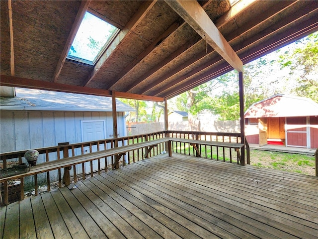 deck with a fenced backyard, an outdoor structure, and a shed