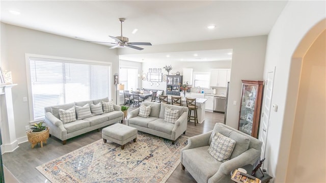 living room with sink, dark wood-type flooring, and ceiling fan