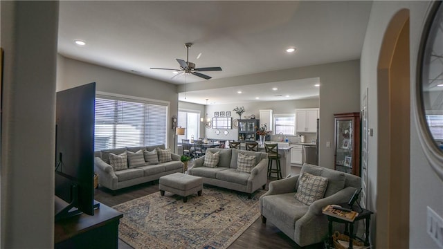 living room with ceiling fan and dark hardwood / wood-style flooring