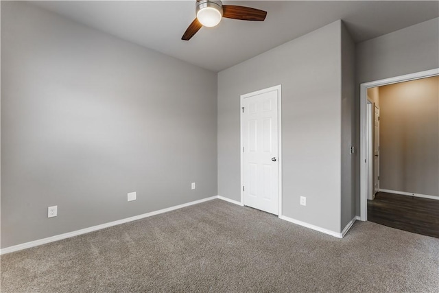 unfurnished bedroom with ceiling fan and dark colored carpet