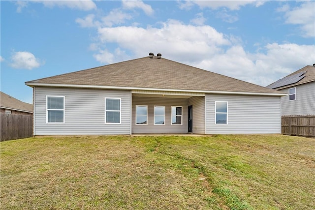 rear view of property featuring a lawn