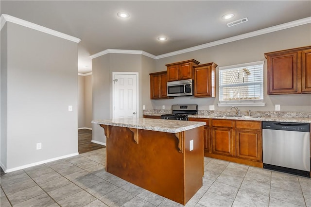 kitchen with a kitchen island, sink, crown molding, a breakfast bar area, and stainless steel appliances