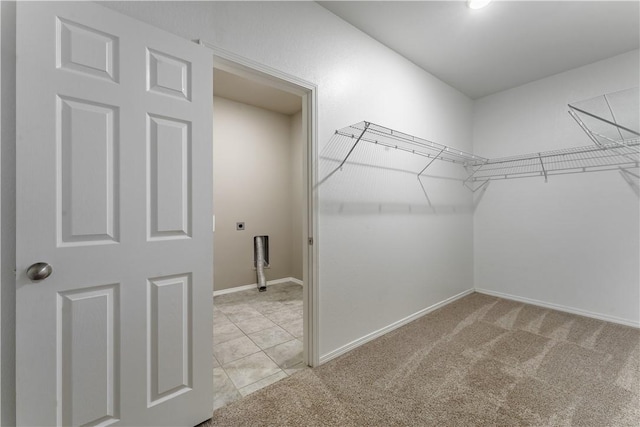 walk in closet featuring light colored carpet