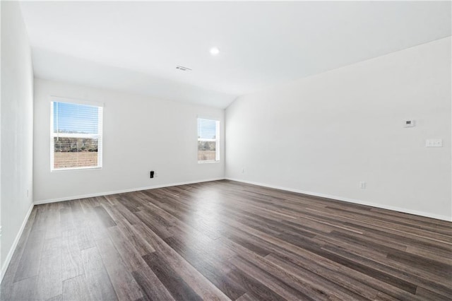 spare room with vaulted ceiling and dark hardwood / wood-style floors