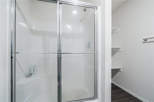 bathroom featuring hardwood / wood-style flooring and a shower with door