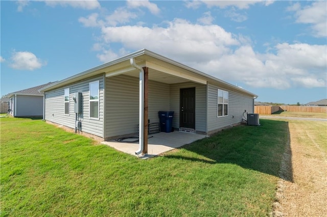 rear view of house with a patio area, a lawn, and central AC