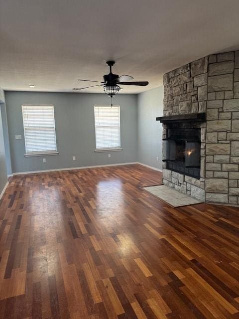 unfurnished living room featuring ceiling fan, a stone fireplace, and hardwood / wood-style floors