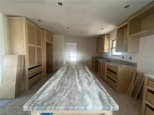 kitchen with sink, a center island, and light brown cabinetry