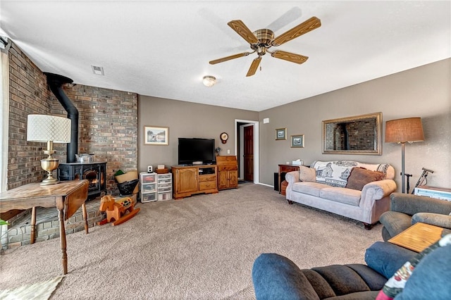 living room featuring a wood stove, ceiling fan, and light carpet