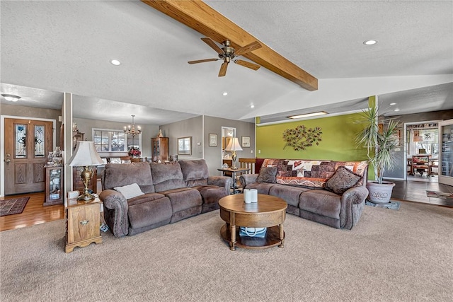 carpeted living room featuring ceiling fan with notable chandelier, a textured ceiling, and vaulted ceiling with beams