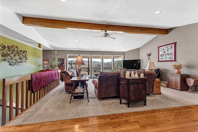 living room featuring light hardwood / wood-style floors, a textured ceiling, vaulted ceiling with beams, and ceiling fan