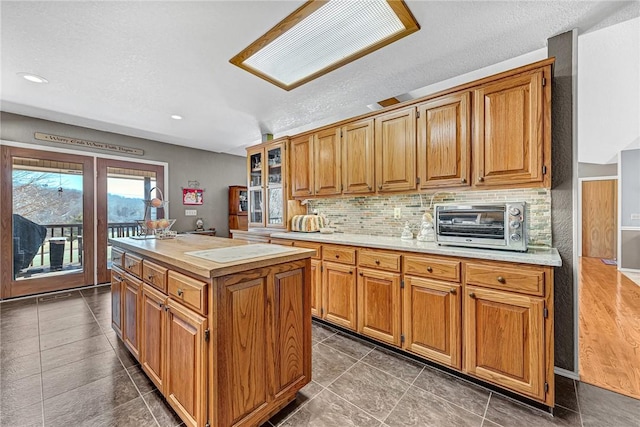 kitchen with decorative backsplash, a textured ceiling, and a center island