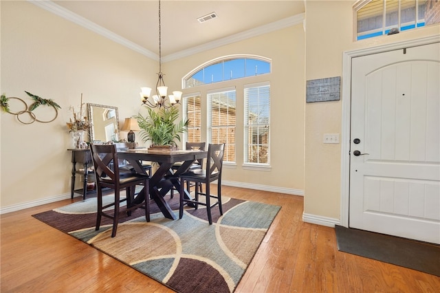 dining room featuring ornamental molding, an inviting chandelier, and hardwood / wood-style floors