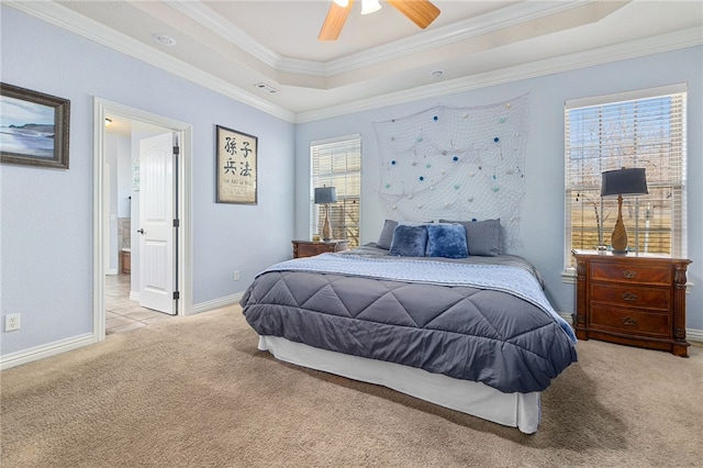 carpeted bedroom featuring ceiling fan, ornamental molding, multiple windows, and a tray ceiling