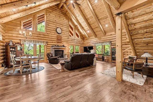 living room featuring hardwood / wood-style floors, wooden ceiling, high vaulted ceiling, beamed ceiling, and rustic walls