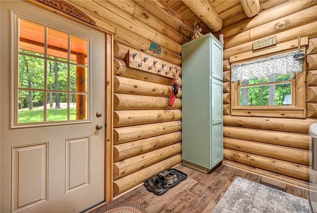 entryway with beam ceiling and log walls