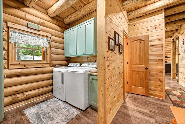 clothes washing area with wooden ceiling, dark hardwood / wood-style flooring, cabinets, and independent washer and dryer