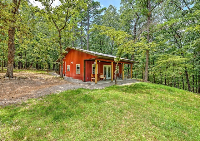 view of outdoor structure featuring french doors and a lawn