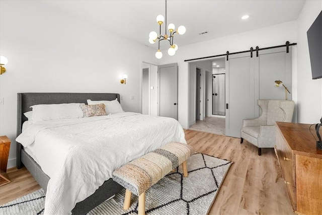 9188 Park Rd, Rogers, AR 72756 - bedroom with light wood-style floors, a barn door, recessed lighting, and an inviting chandelier