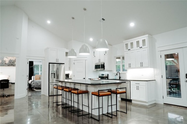 kitchen with white cabinetry, decorative backsplash, hanging light fixtures, and stainless steel appliances