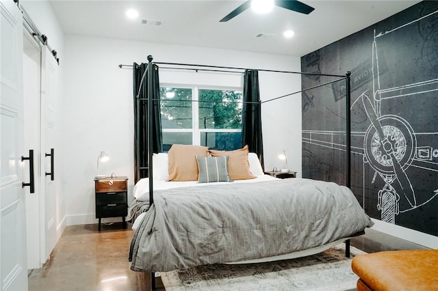 bedroom with ceiling fan and a barn door