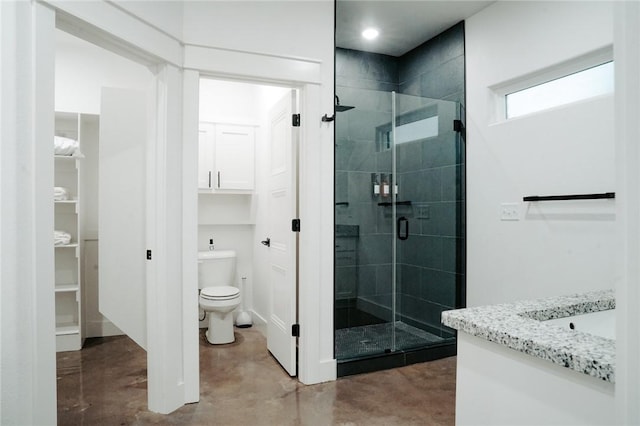 bathroom with a shower with door, toilet, concrete flooring, and vanity