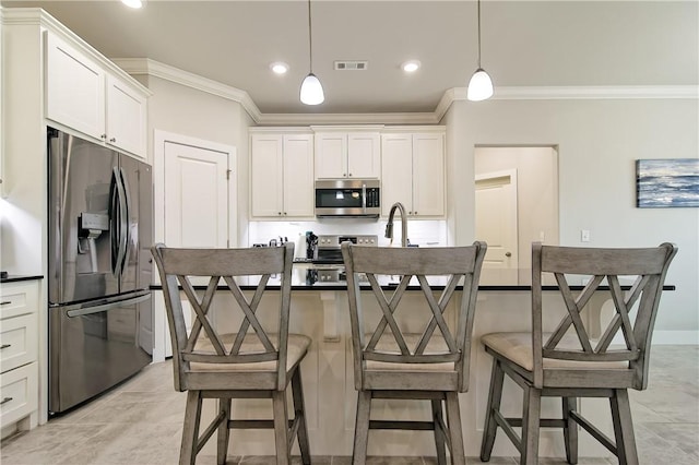 kitchen featuring a center island with sink, hanging light fixtures, stainless steel appliances, white cabinets, and crown molding