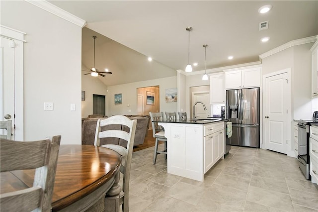 kitchen with a kitchen breakfast bar, stainless steel appliances, decorative light fixtures, white cabinetry, and a kitchen island with sink