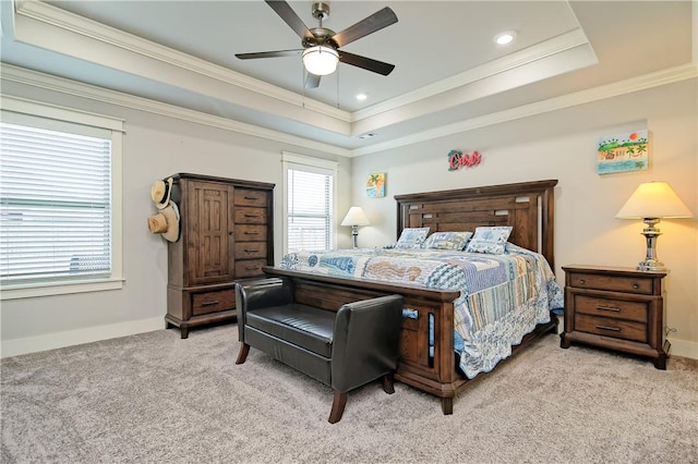 carpeted bedroom with ornamental molding, ceiling fan, and a raised ceiling