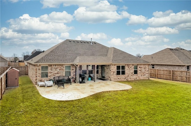 back of property featuring a storage unit, a patio, and a lawn