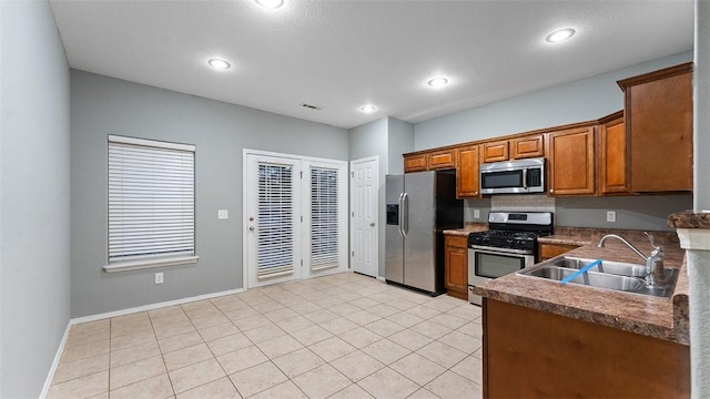 kitchen featuring tasteful backsplash, sink, light tile patterned flooring, and appliances with stainless steel finishes