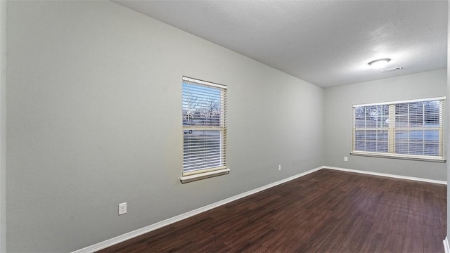 empty room featuring wood-type flooring and a textured ceiling