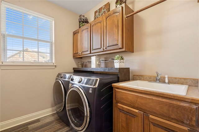 washroom featuring sink, washer and clothes dryer, dark hardwood / wood-style floors, and cabinets