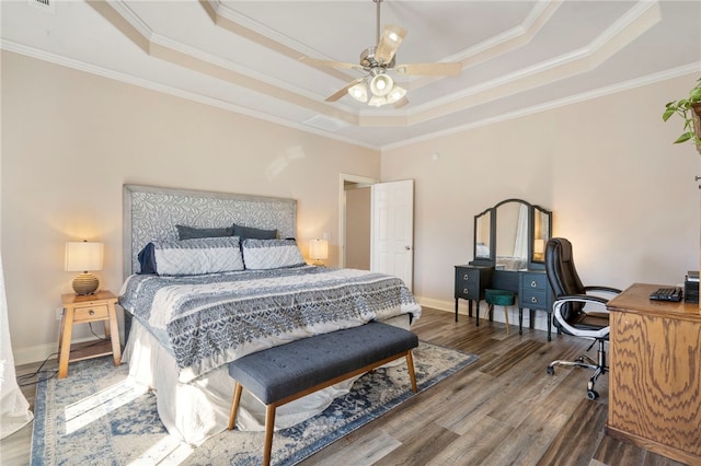 bedroom with crown molding, hardwood / wood-style flooring, ceiling fan, and a raised ceiling