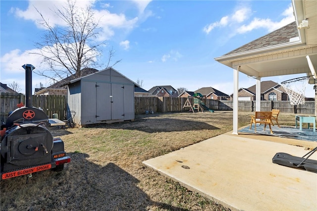 view of yard with a patio, a playground, and a storage shed