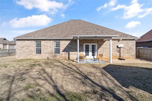 rear view of house with french doors, a patio area, and a lawn