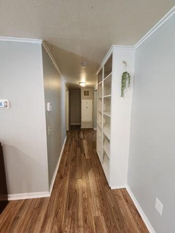 hall with built in shelves, dark wood-type flooring, and ornamental molding